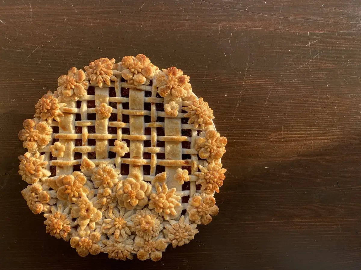 Golden baked floral lattice pie with hand-crafted pastry flowers